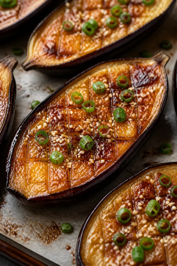 Close-up detail of miso-glazed Japanese eggplant halves just out of the broiler: glossy, caramelized