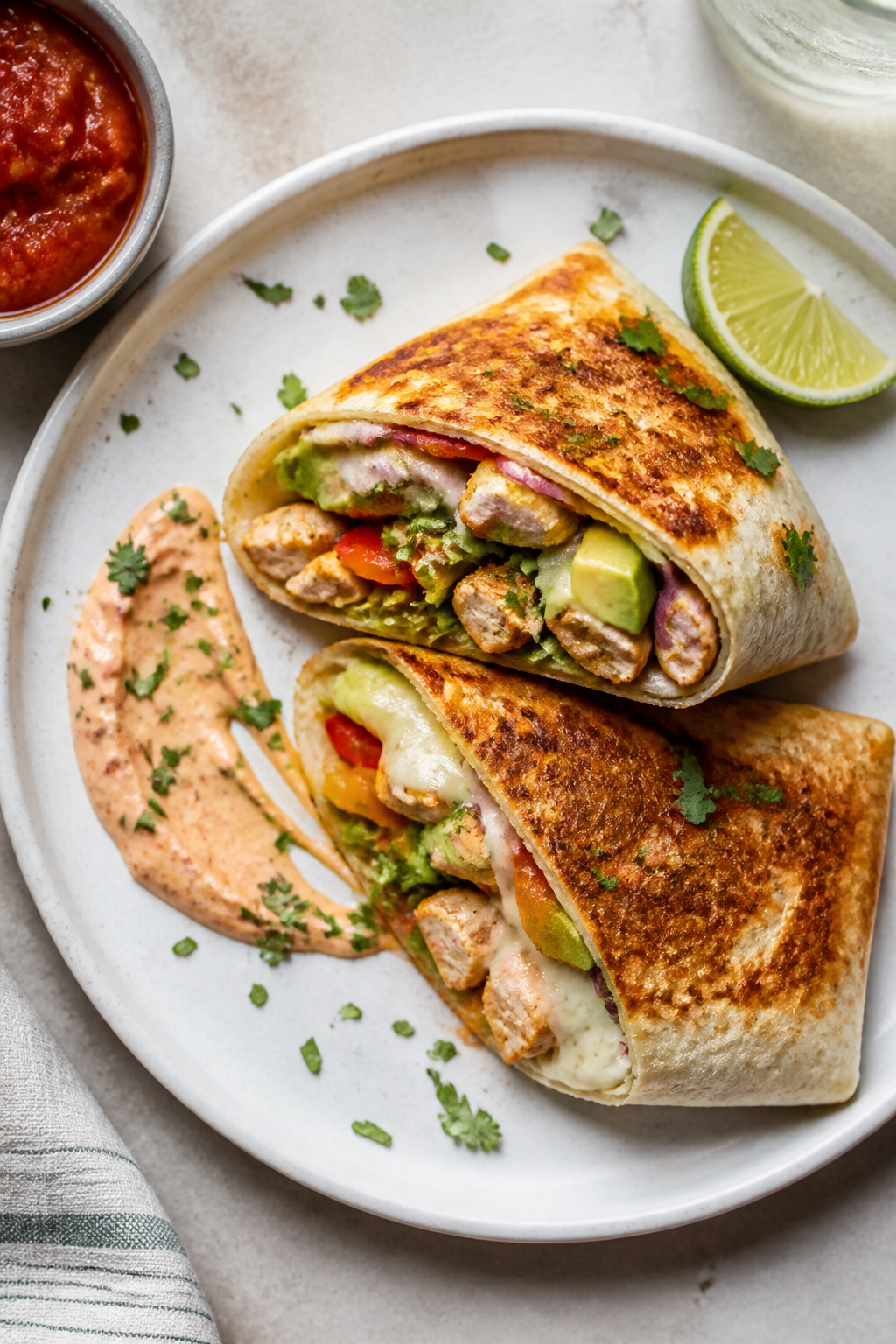Final dish tasty top view: Overhead shot of a toasted keto chicken burrito wrap, sliced on the bias