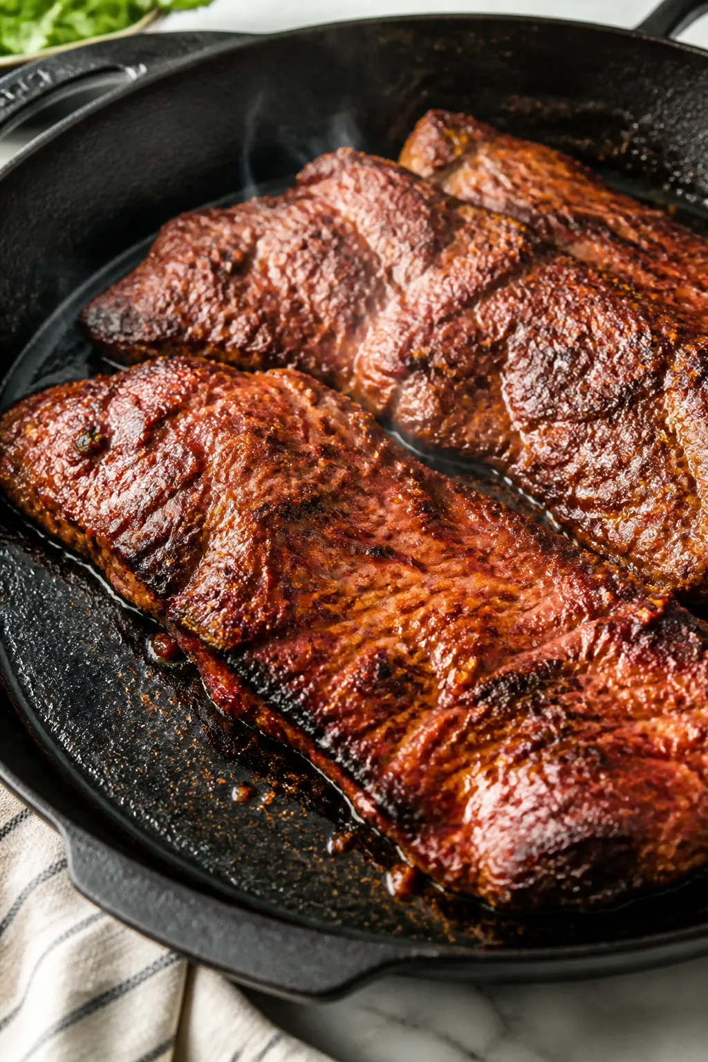 Cooking process, close-up detail: Sizzling carne asada-style skirt steak in a preheated cast-iron sk